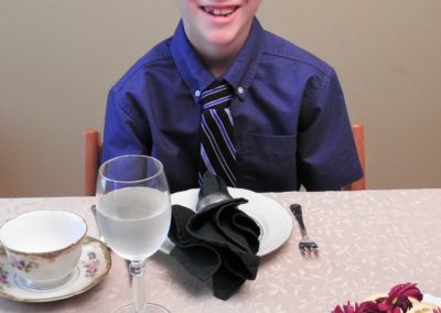 boy in shirt and tie rdinking tea